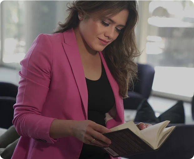 Mujer leyendo un libro en la sección Descubre tu Camino de Be MEE, representando autoconocimiento, guía y crecimiento personal.